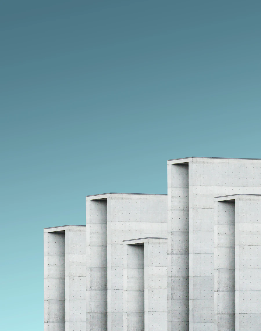 White concrete building with tall vertical fins against a teal sky