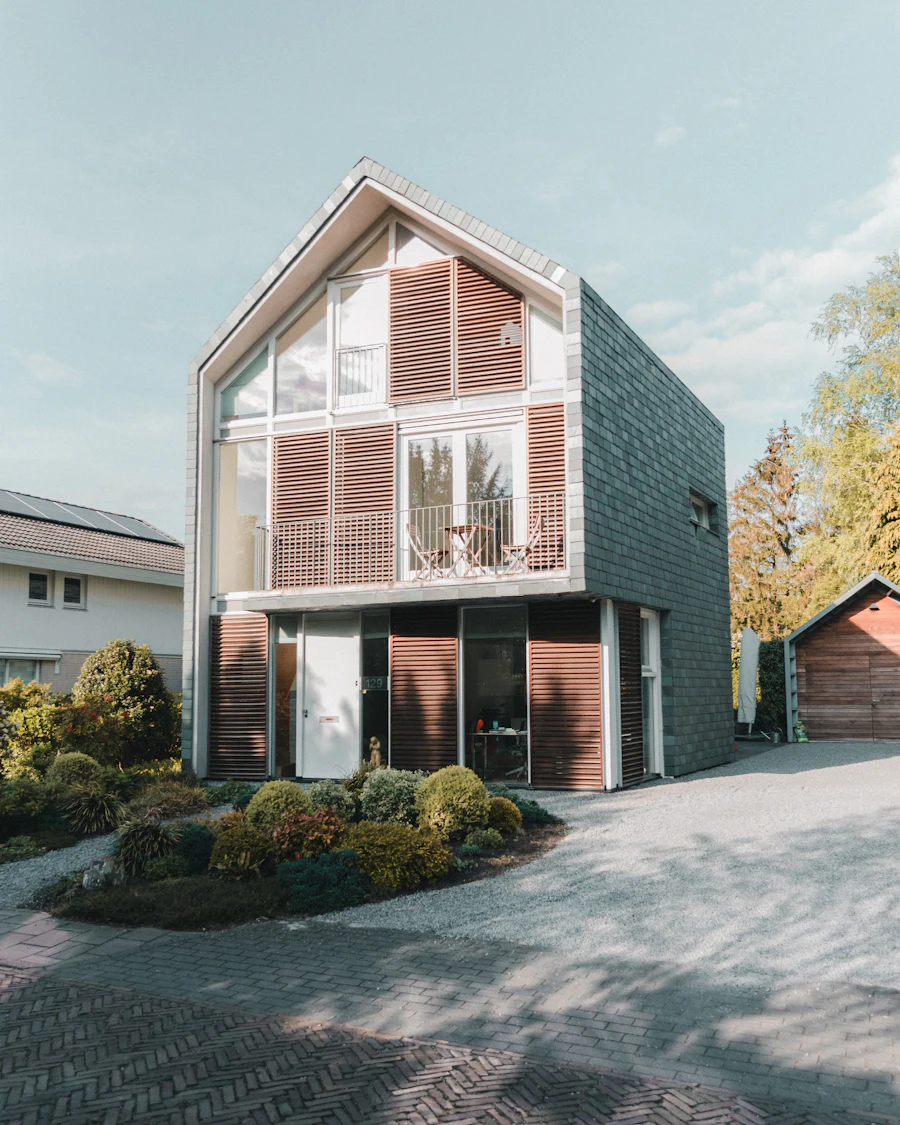 Modern gabled house with a timber-slatted front and a planted courtyard
