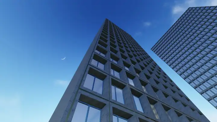 Looking up the glass facade of an office tower against a blue sky